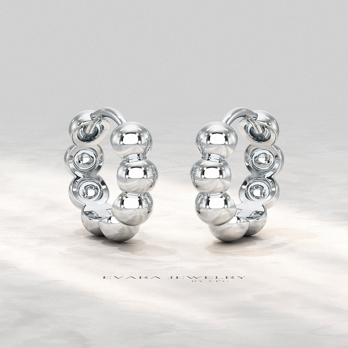 Bold bubble bead hoop earrings displayed on a minimalist jewelry stand.