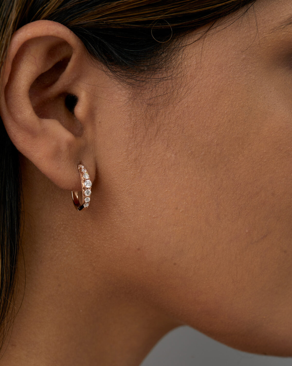 Front view of graduating lab grown diamond hoop earrings with shimmering stones.